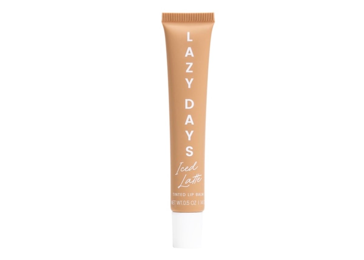 A tan tube of LAZY DAYS Iced Latte tinted lip balm, one of our favorite beauty products, with white text, standing upright on a white background.