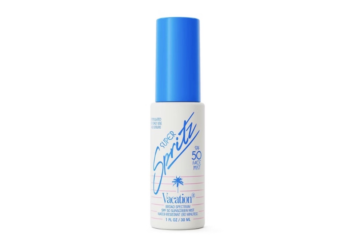 A small white bottle with a blue cap labeled "Super Spritz" SPF 50 Face Mist by Vacation, featuring blue and pink retro-style text and a small palm tree illustration—your must-have for sunny spring break adventures.