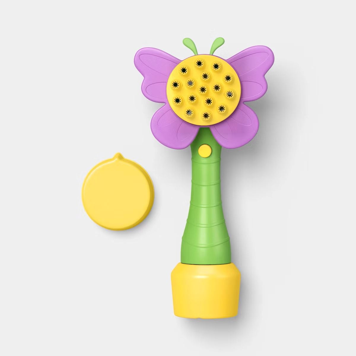 A colorful toy shaped like a butterfly with a green handle, purple wings, and a yellow circular head with black dots, next to a matching yellow cap, on a light gray background.