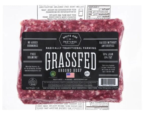 A vacuum-sealed 1-pound package of White Oak Pastures grassfed ground beef, labeled as 90% lean, 10% fat, with claims of no added hormones, no antibiotics, and free roaming cattle.