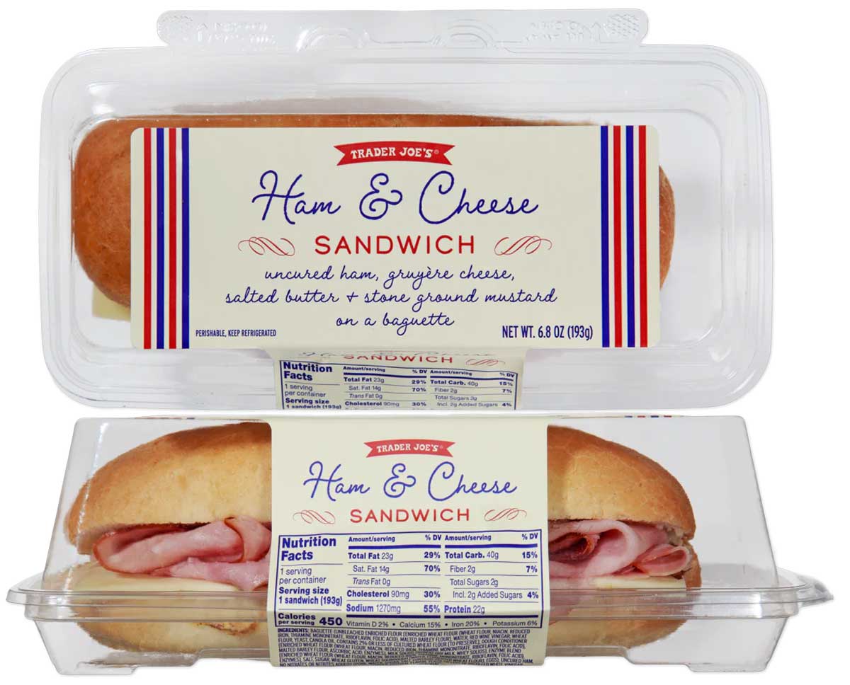 A packaged Trader Joe’s Ham & Cheese Sandwich, one of the Trader Joe's New April Items, features ham, gruyère cheese, salted butter, and stone ground mustard on a baguette in a clear plastic container with the label visible.