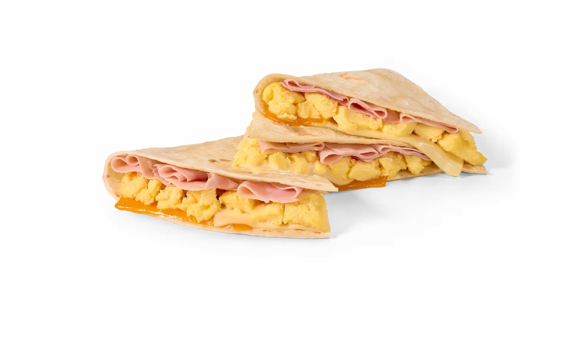 Two breakfast quesadillas filled with scrambled eggs, ham, and melted cheddar cheese, stacked on a white background.
