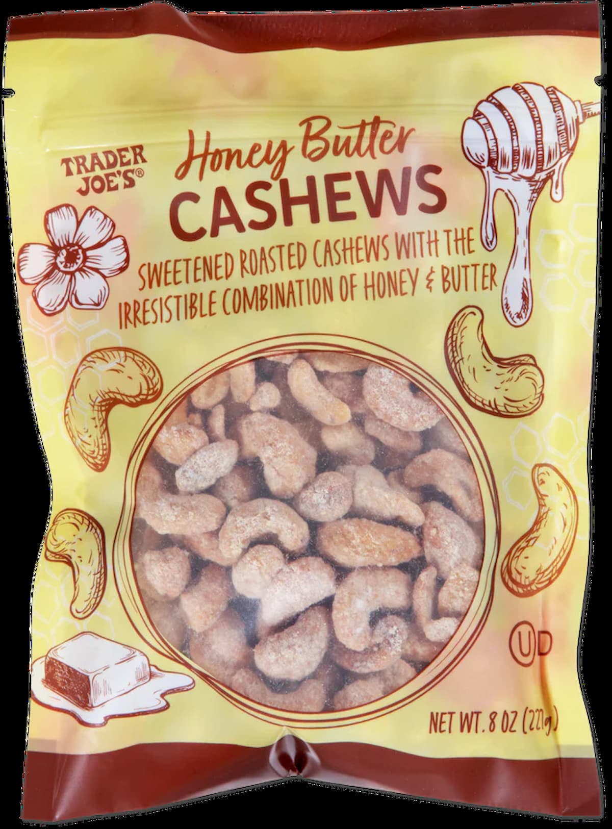 A bag of Trader Joe's Honey Butter Cashews featuring illustrations of cashews, a honey dipper, a butter pat, and a flower. The cashews are visible through a clear window on the front of the yellow and orange packaging.