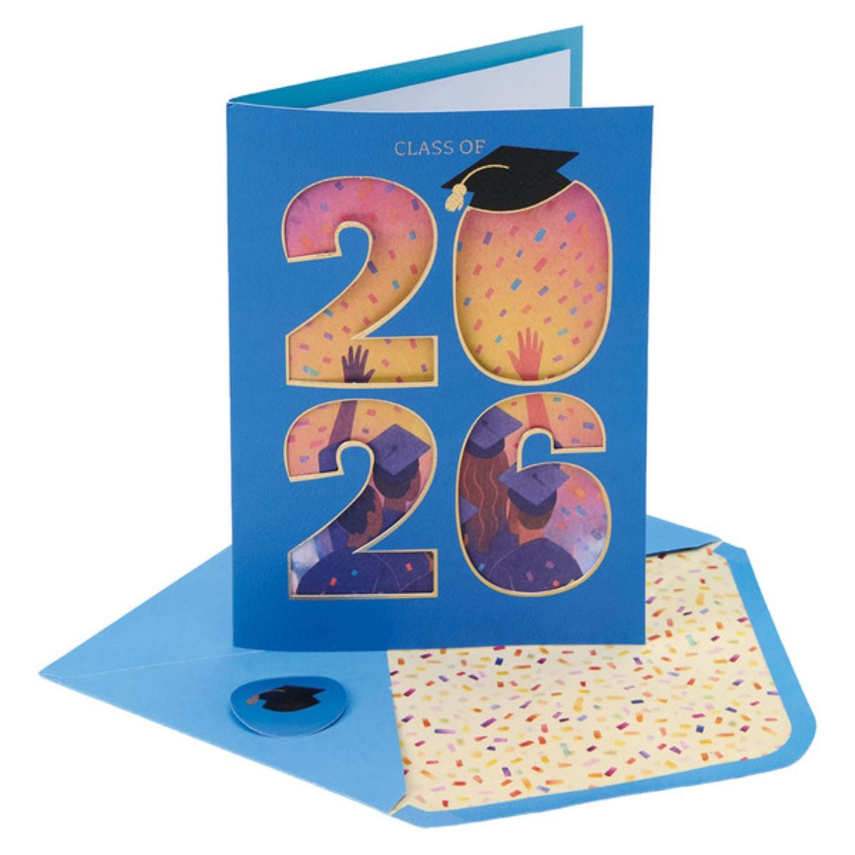 A blue graduation card with "2026" on the front, confetti background, and silhouettes of graduates tossing caps. The card is paired with a matching envelope lined with colorful confetti and a graduation cap sticker.