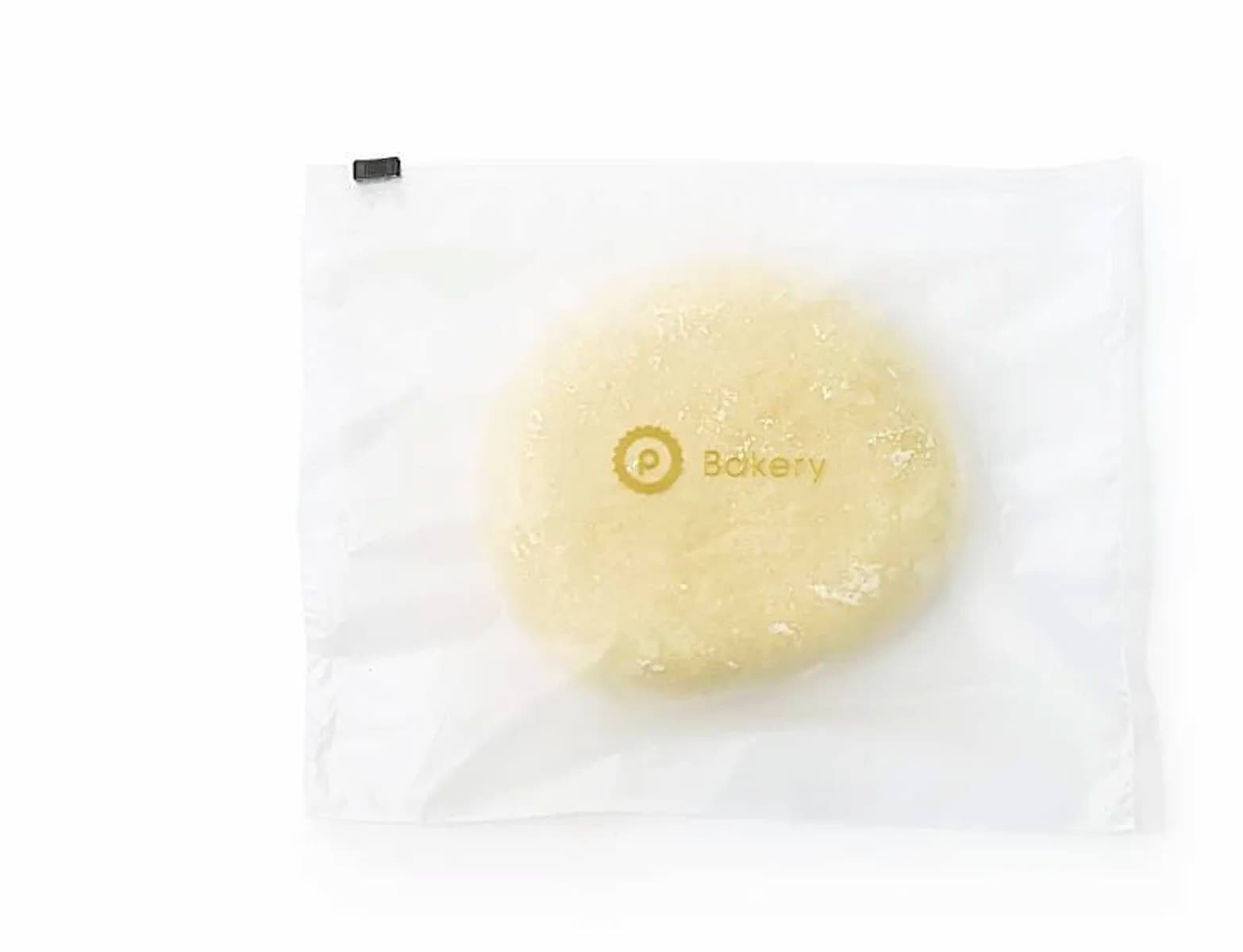 A ball of dough in a clear, resealable plastic bag labeled "Bakery" with a circular logo, placed on a white background.