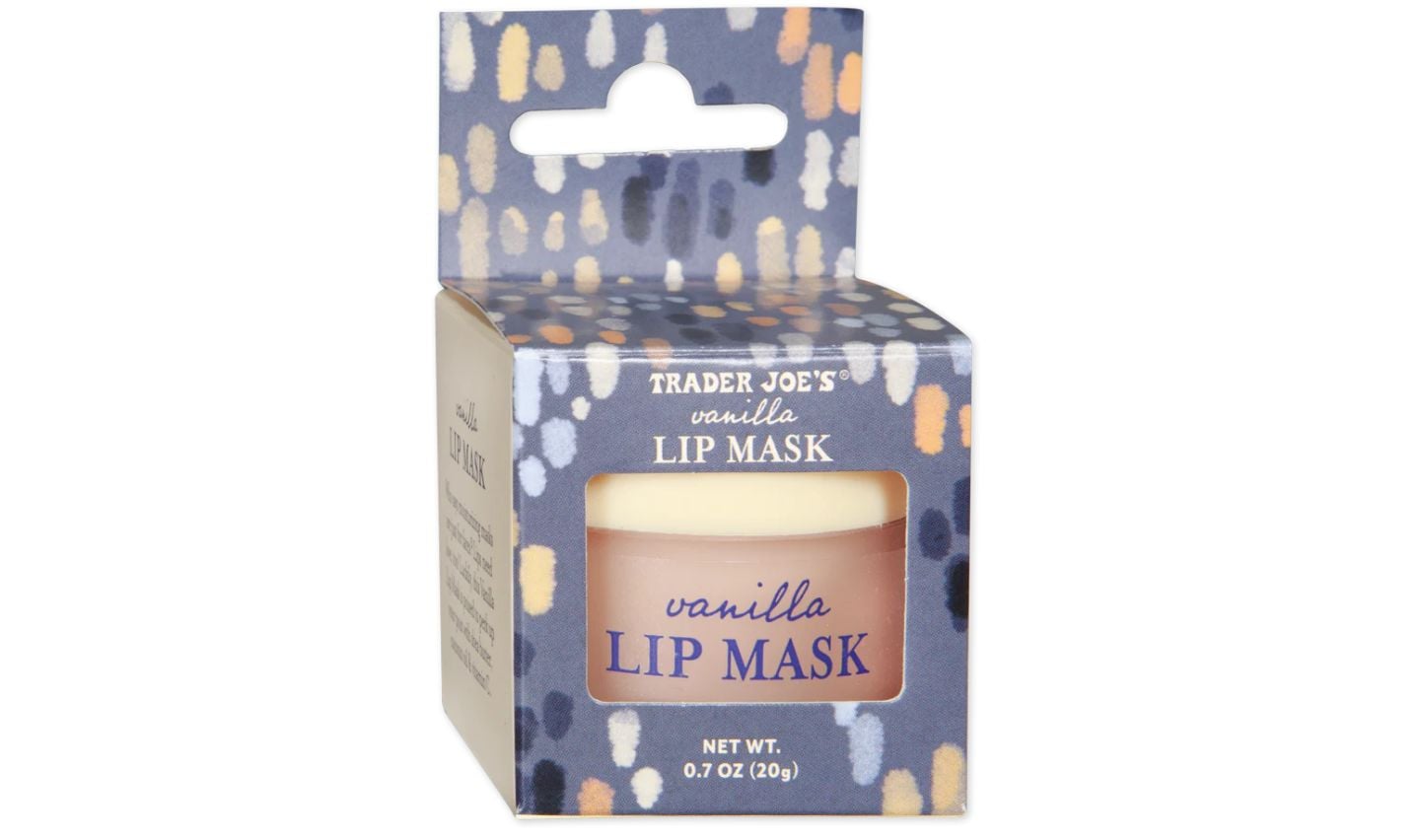 A Trader Joe's vanilla lip mask in a small round container, packaged in a blue and white patterned box with "vanilla LIP MASK" text on the front. Perfect for pampering, it makes an ideal pick for Trader Joe's Mother's Day gifts. Net weight: 0.7 oz (20g).