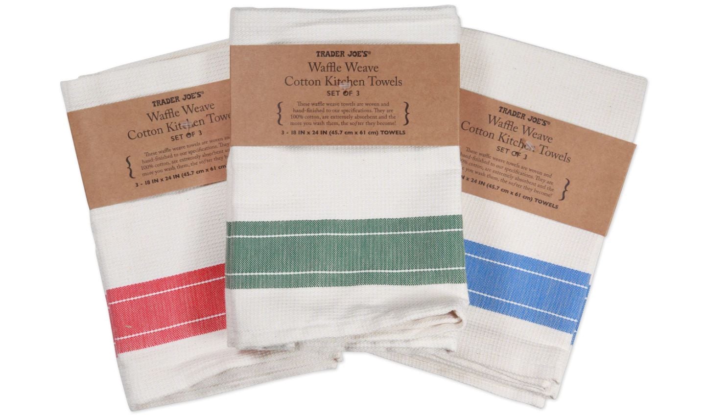 Three folded Trader Joe's waffle weave cotton kitchen towels are shown, each with a brown label—an ideal pick for Trader Joe's Mother's Day gifts. The towels are white with red, green, and blue stripes.
