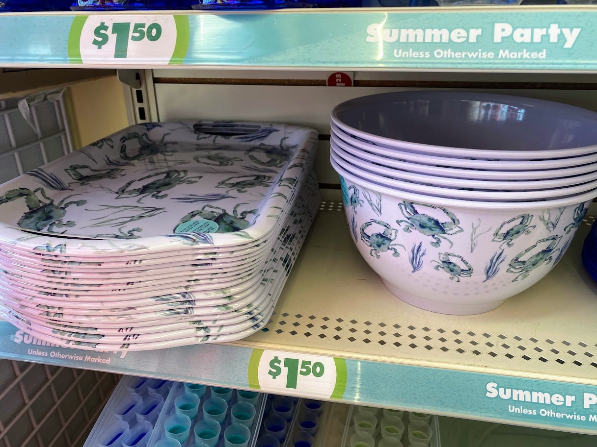 Several rectangular plates with sea-themed designs and large bowls with crab illustrations are displayed on a store shelf, both priced at $7.50. Signs above read "Summer Party Unless Otherwise Marked.