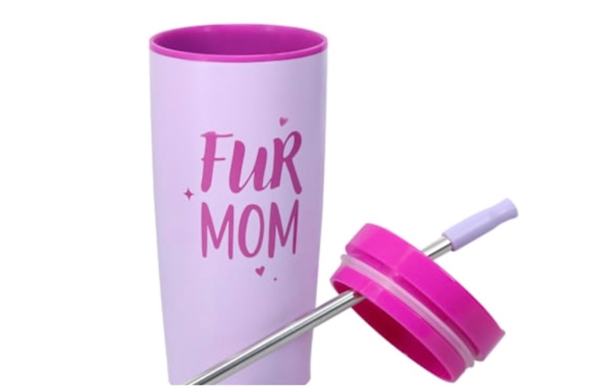 A pink travel tumbler from Five Below with the words "Fur Mom" written on it, shown with a matching pink lid and a metal straw placed beside it.