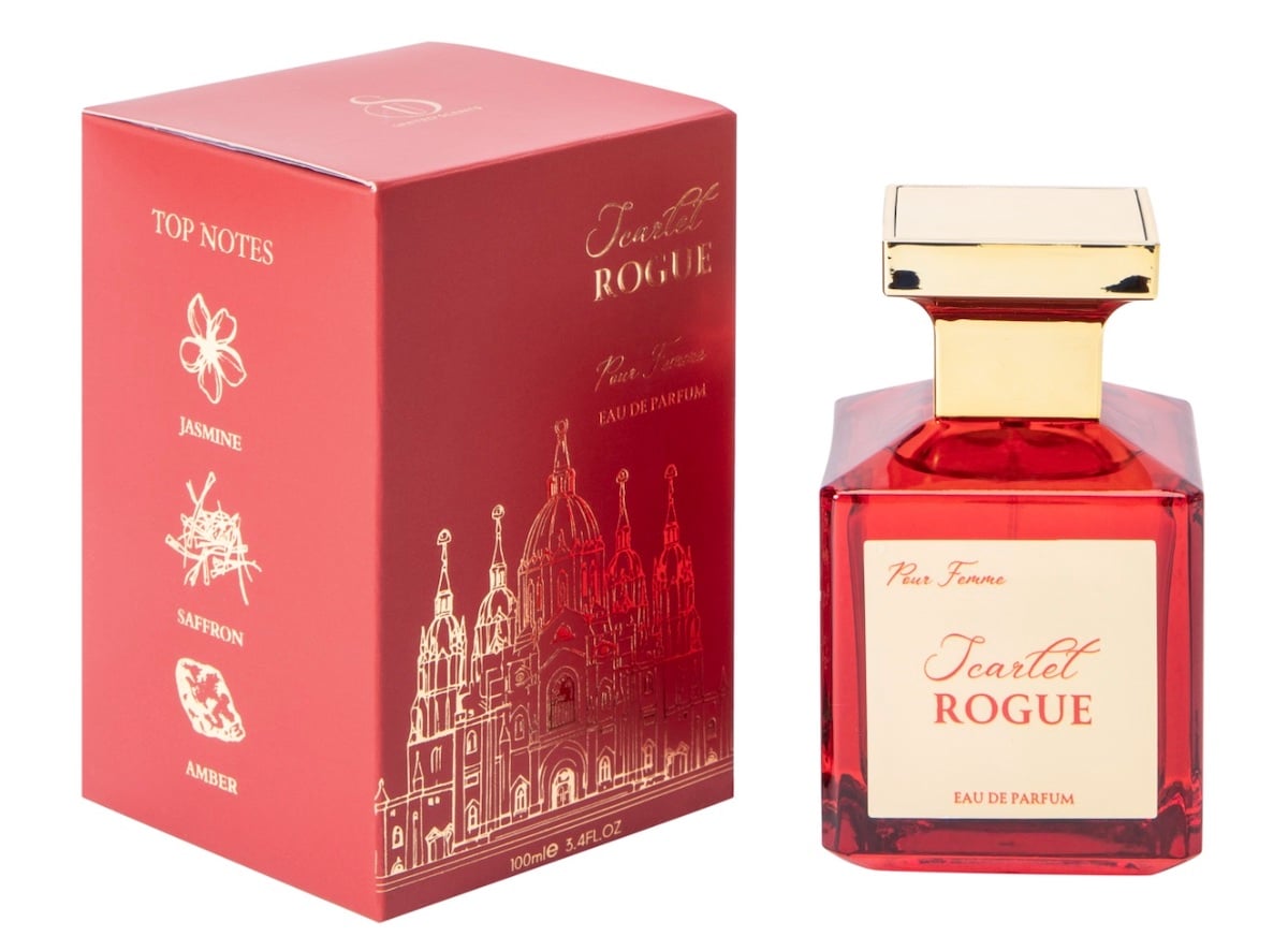 A red bottle of Scarlet Rogue eau de parfum with a gold cap sits next to its matching red and gold box, featuring illustrations and listing top notes of jasmine, saffron, and amber—an elegant find you wouldn’t expect at five below.