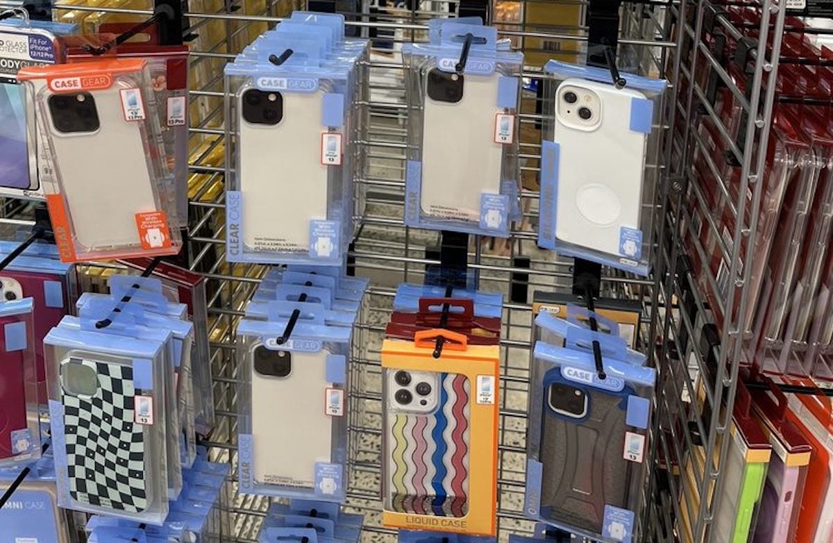 Several phone cases are displayed on metal racks—clear, solid color, checkered, and wavy designs—all in plastic packaging with blue and orange accents, perfect for your first time at Five Below.