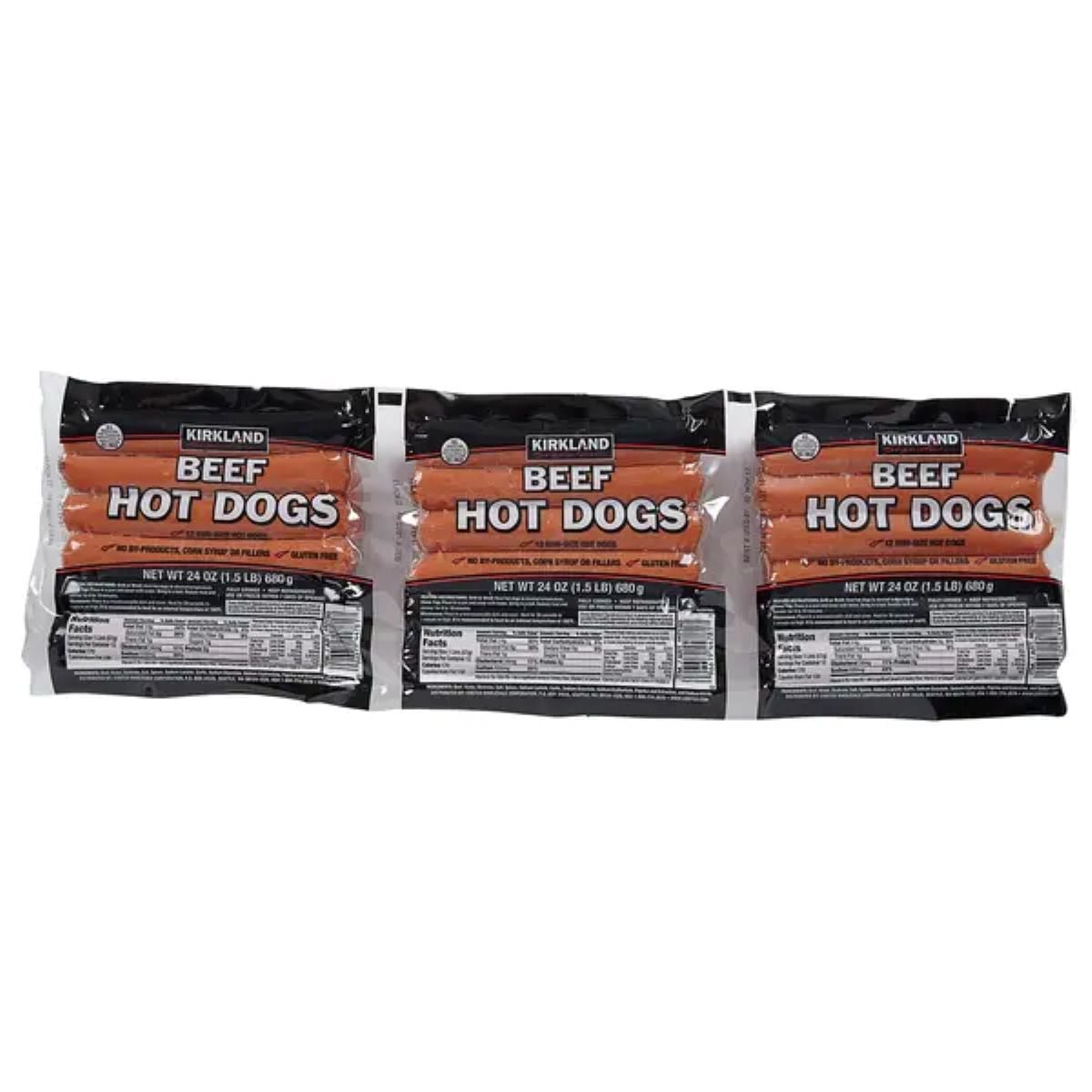 Three packs of Kirkland Signature Beef Hot Dogs, each containing hot dog sausages in clear plastic packaging with black labels and orange text, displayed side by side.