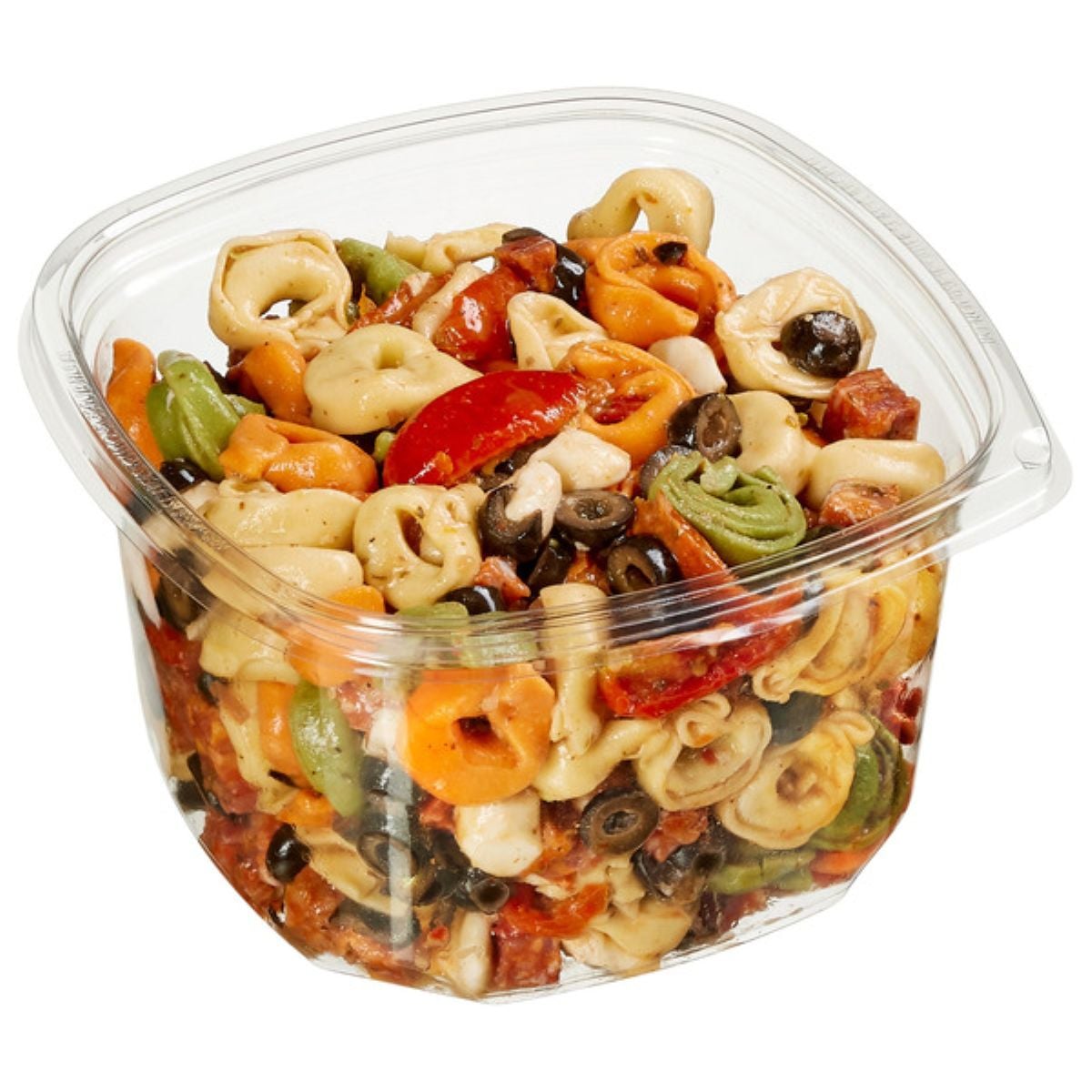 A clear plastic container filled with colorful tortellini pasta salad, including green, orange, and white pasta, black olives, sliced cherry tomatoes, and chunks of cheese.
