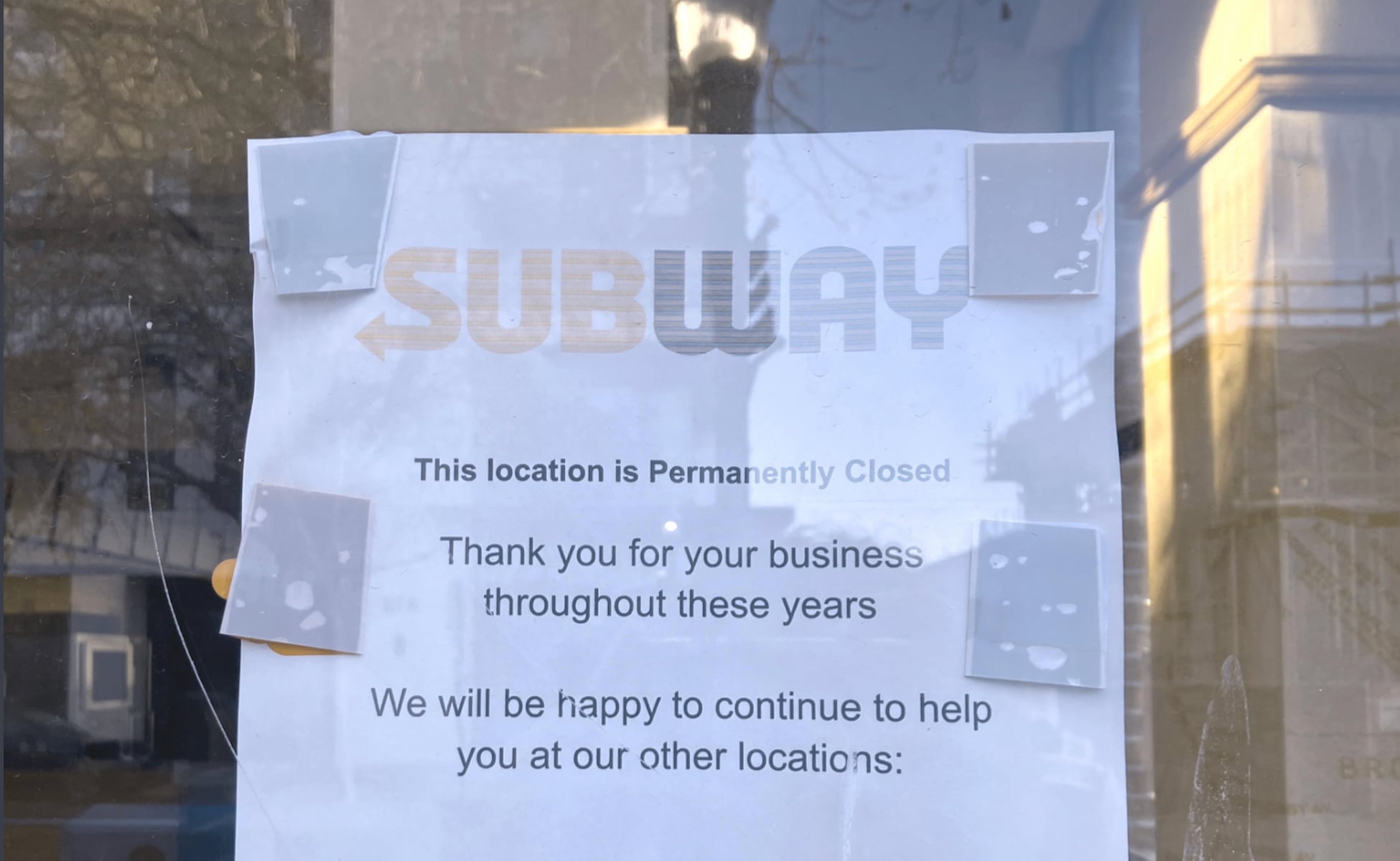A printed sign taped to a window reads: “SUBWAY. This location is permanently closed. Thank you for your business throughout these years. We will be happy to continue to help you at our other locations.”