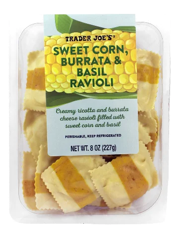 A clear plastic package of Trader Joe’s Sweet Corn, Burrata & Basil Ravioli. The label shows yellow and white striped ravioli and describes the filling as creamy ricotta, burrata, sweet corn, and basil.