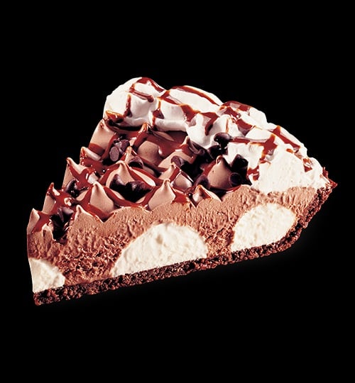 A slice of chocolate cream pie with whipped topping, chocolate shavings, and chocolate drizzle—layered with rich chocolate and cream on a chocolate crust—showcases the indulgence found in classic fast-food desserts against a black background.
