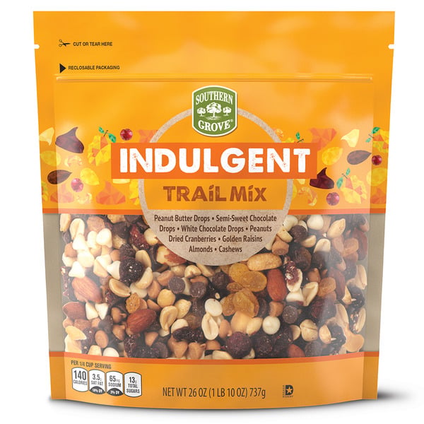 A resealable bag of Southern Grove Indulgent Trail Mix, showing a mix of nuts, raisins, cranberries, and chocolate drops on the front. The label highlights ingredients and nutritional info.