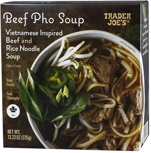 Box of Trader Joe's Beef Pho Soup, showing a bowl of pho with beef, rice noodles, bean sprouts, basil, lime, and jalapeño slices. The text highlights it as Vietnamese inspired beef and rice noodle soup.