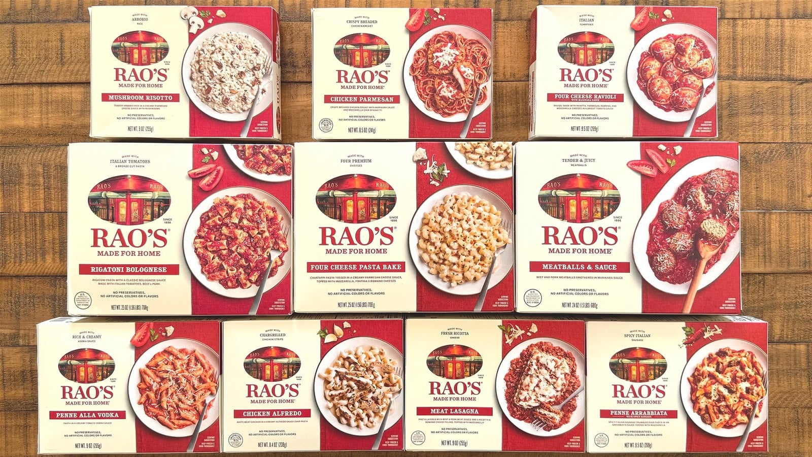 Boxes of Rao’s Made for Home frozen meals are arranged in three rows on a wooden surface. Varieties include Mushroom Risotto, Chicken Parmesan, Meatballs & Sauce, Penne Alla Vodka, and other Italian-inspired dishes.