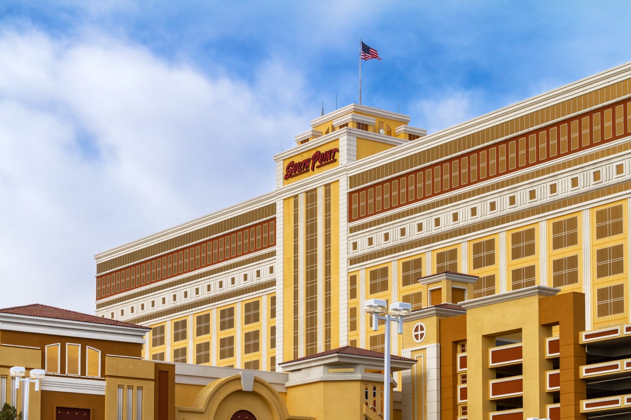 A large, yellow and beige hotel building with the words "Green Valley Ranch" at the top, featuring rows of windows and an American flag flying on the roof—an inviting spot for those seeking Las Vegas budget tips under a partly cloudy sky.