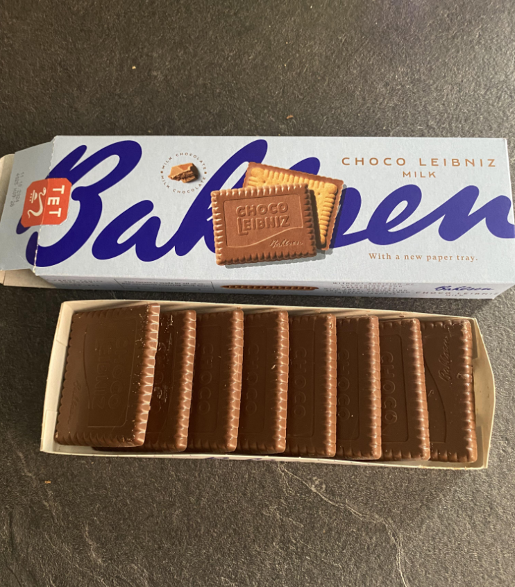 A box of Bahlsen Choco Leibniz milk chocolate biscuits, with one biscuit placed on top of the box and several more aligned neatly in an open tray.