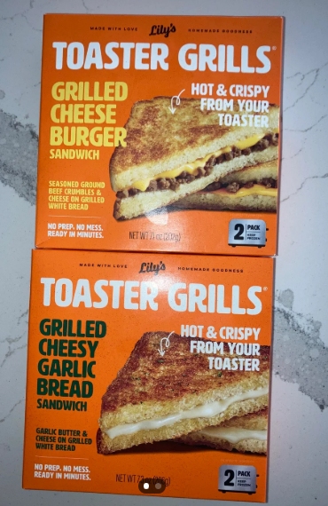 Two boxes of Lily's Toaster Grills sandwiches sit on a countertop—Grilled Cheese Burger and Grilled Cheesy Garlic Bread flavors. Both promise hot, crispy sandwiches in minutes and are perfect to buy in bulk for quick, tasty meals anytime.