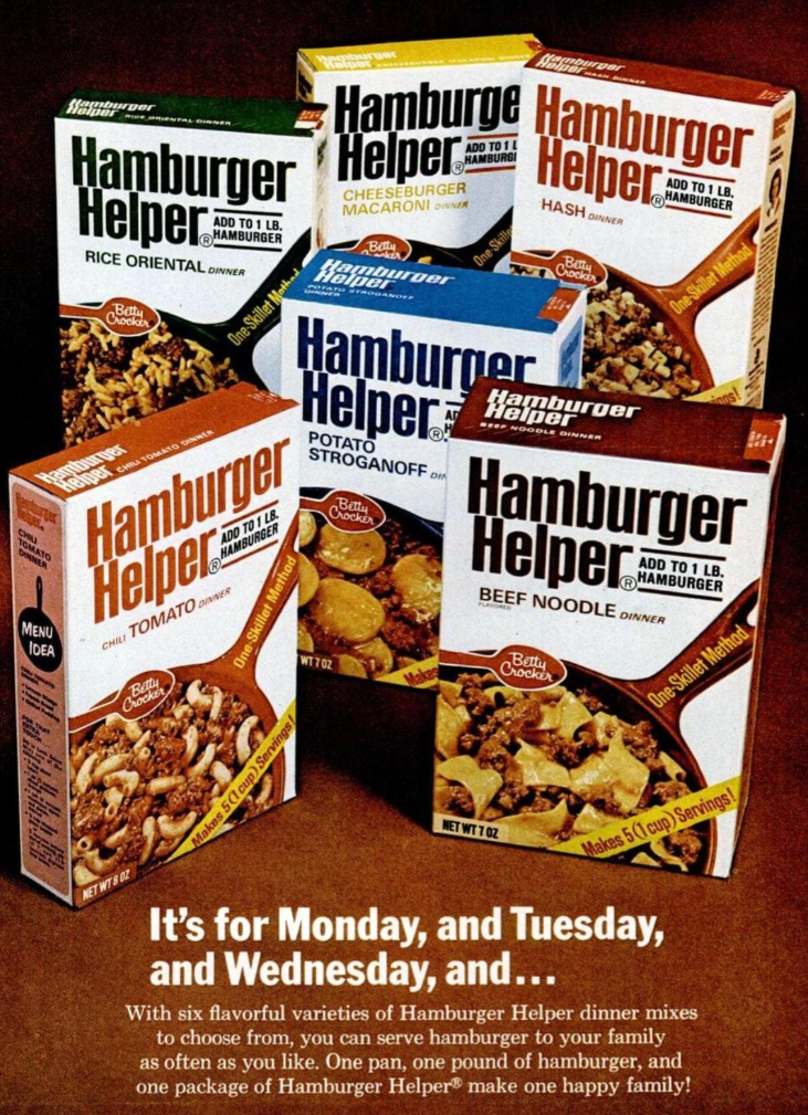 Five colorful boxes of Hamburger Helper dinner mixes—great for budget meals—include Rice Oriental, Cheeseburger Macaroni, Hash Browns, Italian Tomato, Potato Stroganoff, and Beef Noodle, arranged above a table with a serving of prepared food.