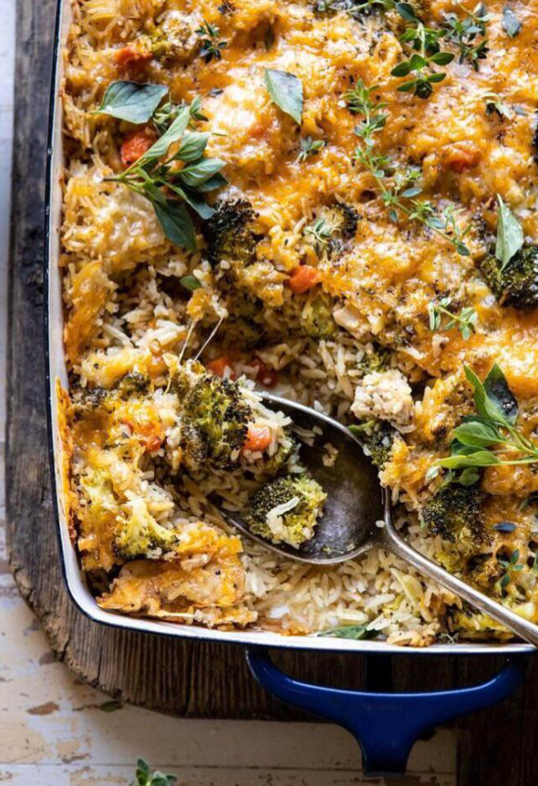 A baking dish filled with a cheesy broccoli and rice casserole, topped with fresh herbs—a classic meal many middle-class moms cooked. A serving has been scooped out, revealing the hearty rice and vegetables inside.