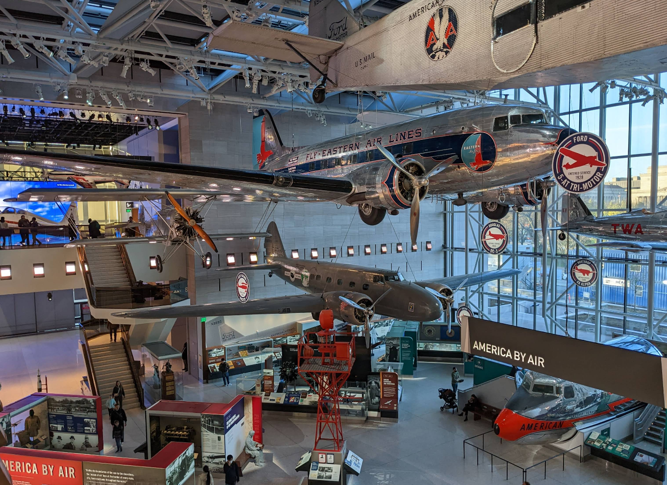 Historic airplanes, including a silver Eastern Air Lines plane, are suspended from the ceiling in this spacious, well-lit museum—one of the city’s top tourist attractions—with visitors observing fascinating aviation exhibits below.