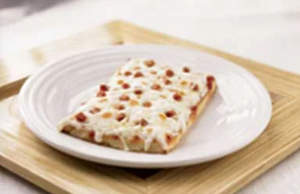 A rectangular slice of pizza topped with melted cheese and small pepperoni pieces sits on a white plate, which is placed on a light wooden tray.