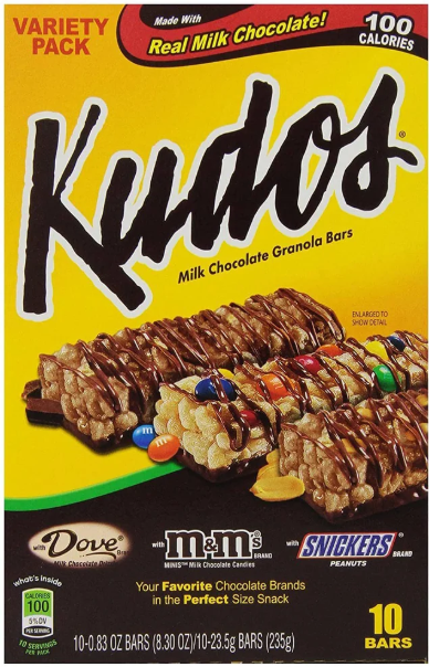 Kudos Variety Pack box featuring milk chocolate granola bars topped with Dove chocolate, M&M's, and Snickers pieces. The package highlights real milk chocolate and contains 10 bars, 100 calories each.