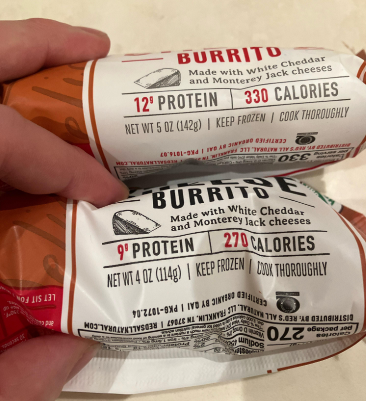 Two hands hold frozen burrito packages. The top package has 12g protein and 330 calories; the bottom has 9g protein and 270 calories. Both are made with white cheddar and Monterey Jack cheese.