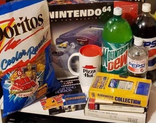 A nostalgic assortment including Doritos chips, a Pizza Hut mug, Mountain Dew, Crystal Pepsi, Pepsi, a Nintendo 64 console, Blockbuster VHS tapes, and a Blockbuster gift card.