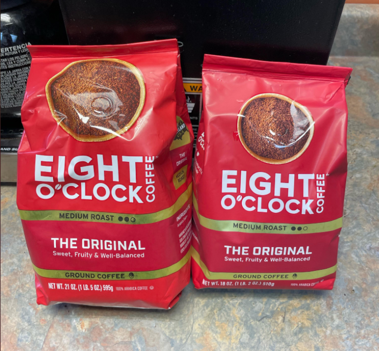 Two red bags of Eight O’Clock Coffee, labeled "The Original" and "Medium Roast," sit side by side on a kitchen counter. The bags describe the coffee as "Sweet, Fruity & Well-Balanced.