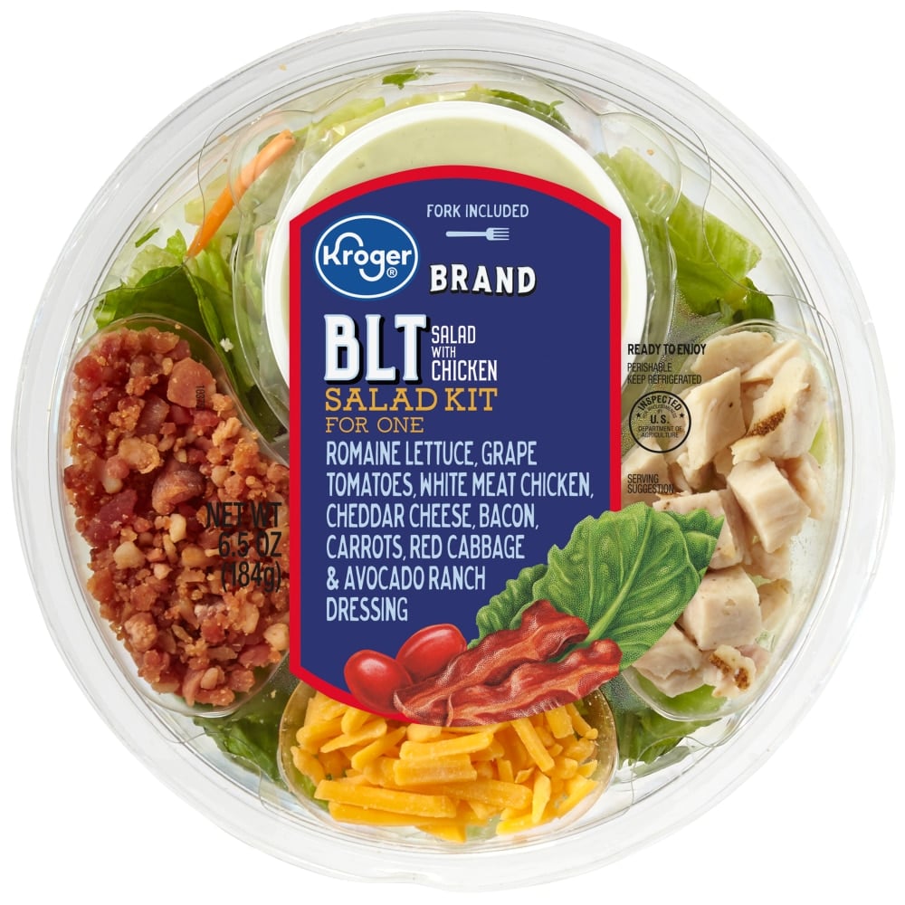 A Kroger BLT Salad Kit for one in a round plastic container, with sections of romaine lettuce, grape tomatoes, white meat chicken, cheddar cheese, bacon, carrots, red cabbage, and a cup of avocado ranch dressing.