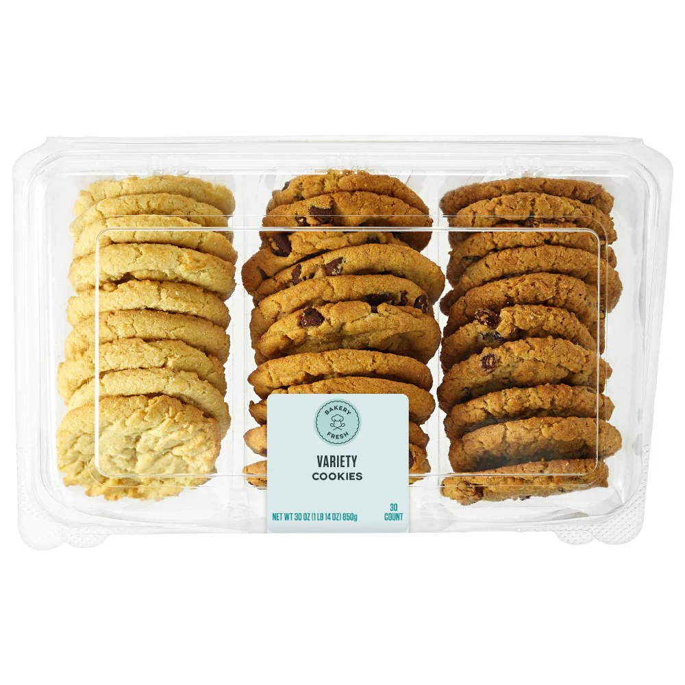 A clear plastic tray containing rows of assorted cookies, including chocolate chip, oatmeal, and sugar varieties, neatly stacked and separated into sections. A label on the front reads "Variety Cookies.