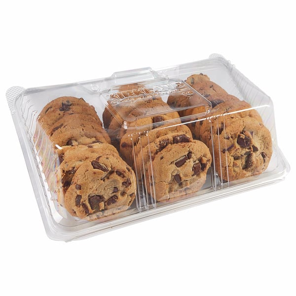 A clear plastic container holds multiple rows of chocolate chip cookies, neatly stacked and visible through the packaging.