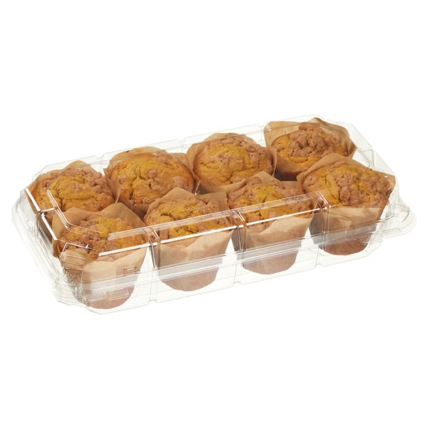 A clear plastic container holds eight large muffins with crumbly, brown streusel topping, each wrapped in brown paper wrappers.