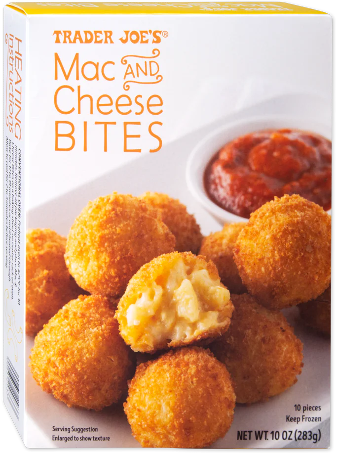 A box of Trader Joe's Mac and Cheese Bites, showing golden, breaded bites on a plate with one cut open to reveal creamy mac and cheese filling, and a dish of marinara sauce in the background.