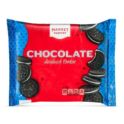 A red and blue package of Market Pantry Chocolate Sandwich Cookies, featuring images of the cookies on the front and nutrition facts displayed at the bottom. Store-brand products. 