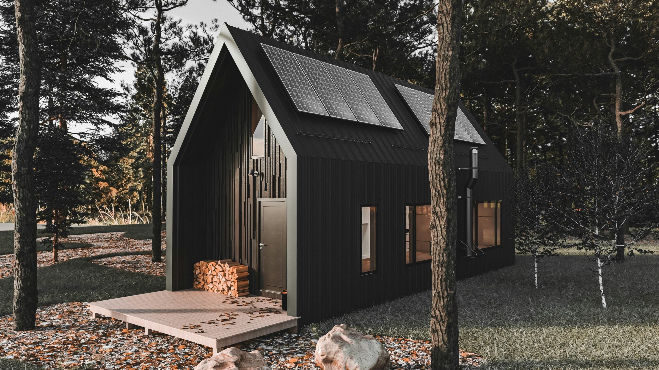 A modern black tiny house with large windows and solar panels on the roof sits among tall pine trees. A small wooden deck with stacked firewood is at the entrance, surrounded by grass and rocks.