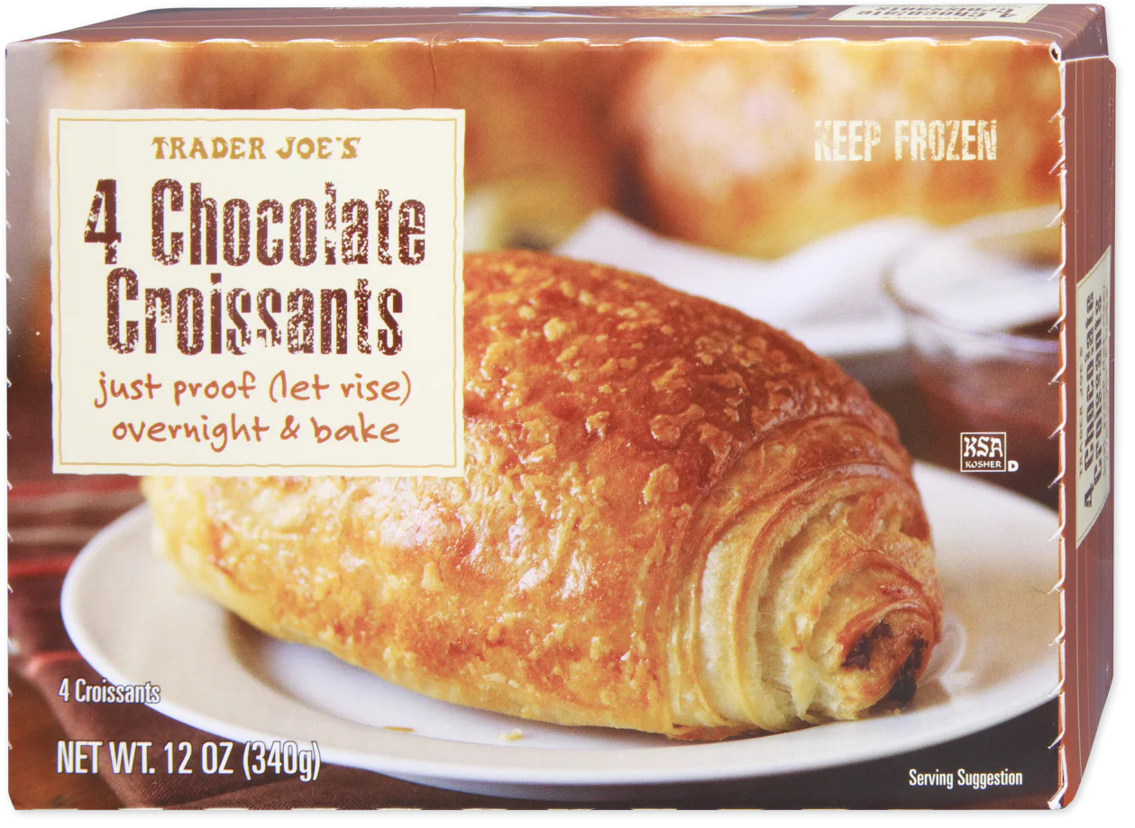 A Trader Joe’s box of 4 Chocolate Croissants, showing a close-up of a golden baked croissant on a plate. The packaging highlights “just proof overnight & bake” instructions and a net weight of 12 oz (340g).