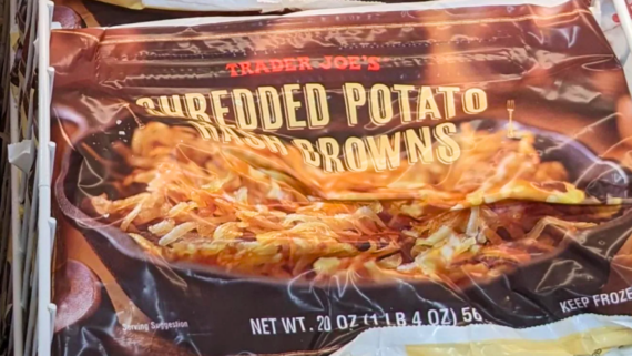 A package of Trader Joe&rsquo;s Shredded Potato Hash Browns, one of the popular Trader Joe's products, features a close-up image of crispy cooked hash browns in a skillet on the front of the 20-ounce bag.