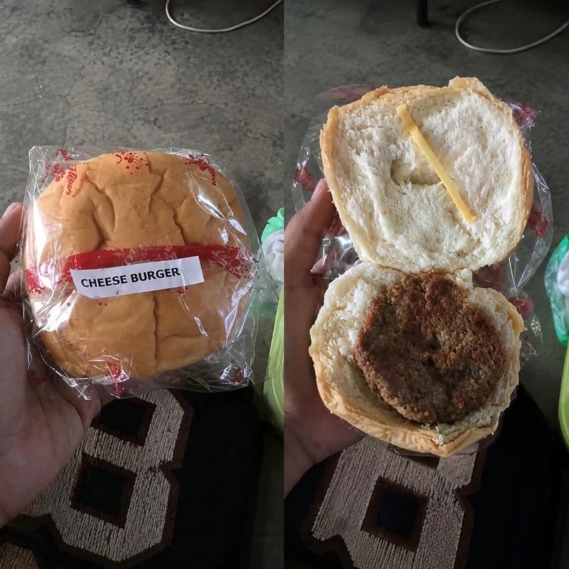 A hand holds a packaged cheeseburger. When opened, the bun reveals a single beef patty and one small slice of cheese.