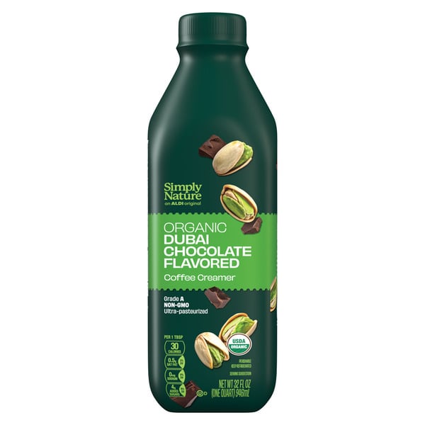 A bottle of Simply Nature Organic Dubai Chocolate Flavored Coffee Creamer with images of pistachios and chocolate pieces on a dark green label.