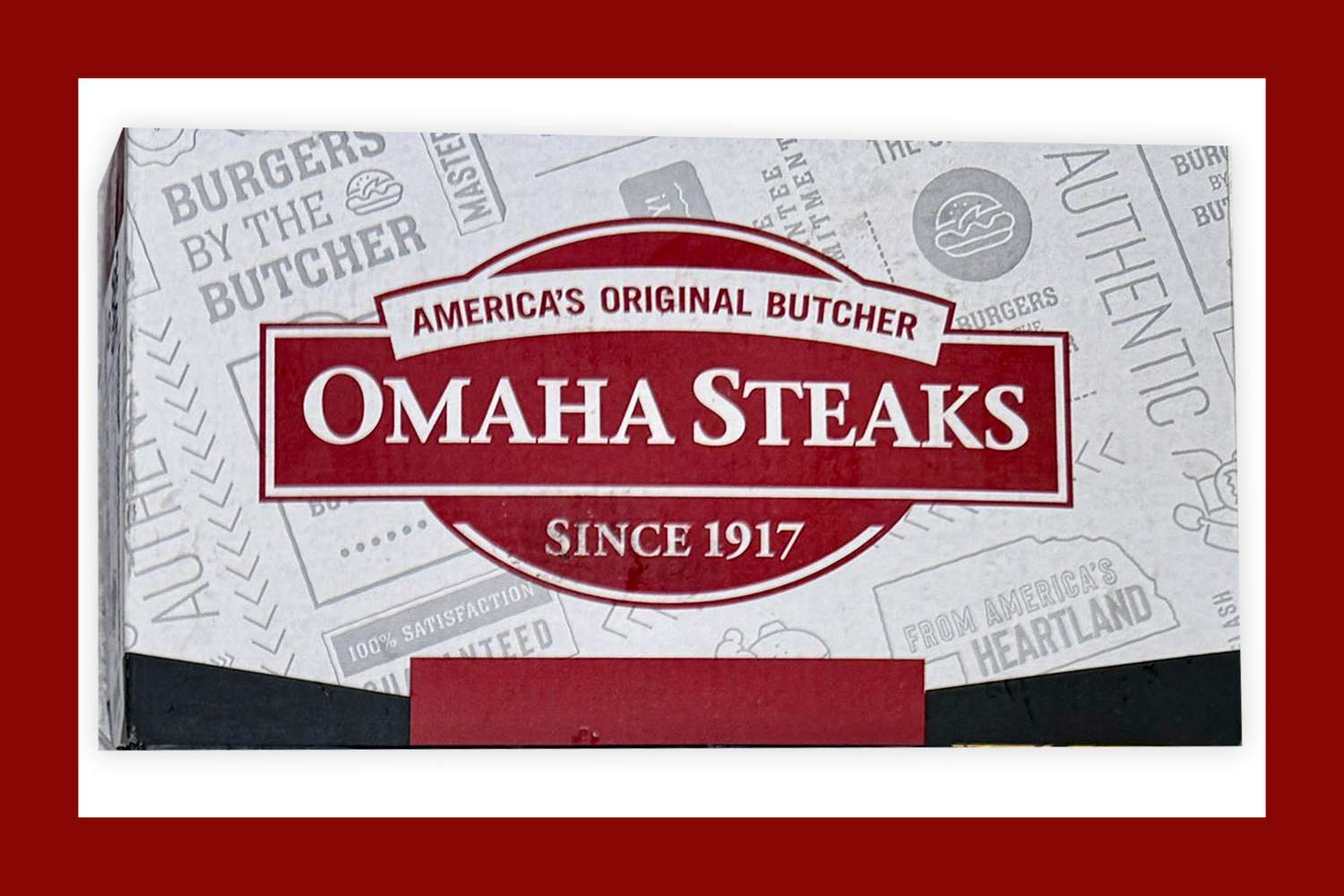 A box displaying the Omaha Steaks logo, reading "America's Original Butcher, Omaha Steaks, Since 1917," with a red border and various butcher-themed illustrations in the background.