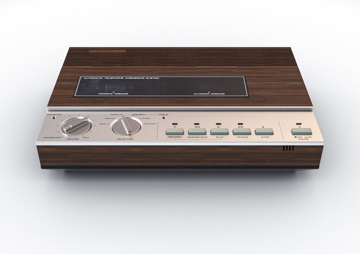 A vintage tabletop radio with a wood grain finish, two large control knobs, several rectangular buttons, and a display panel on the front—just like the classic household staple found in many Middle-Class Moms' kitchens in the 80s and 90s.