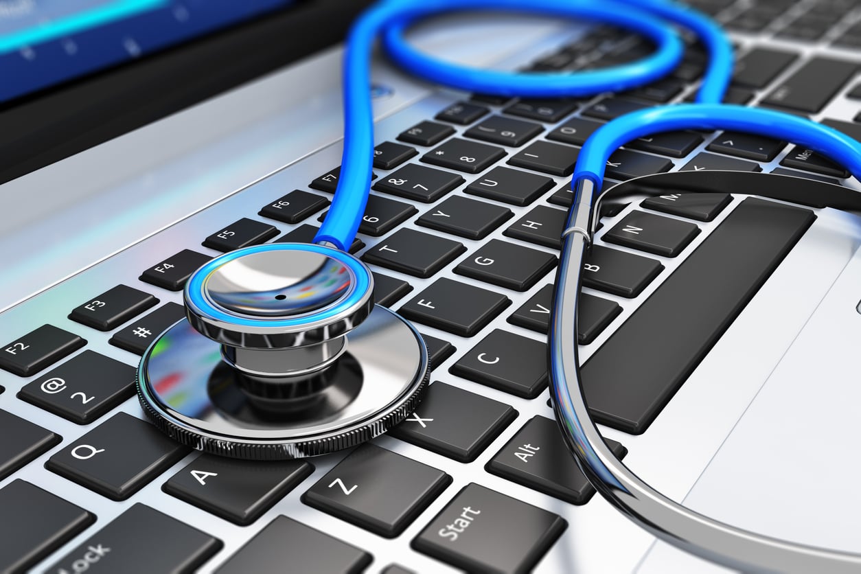 A blue stethoscope resting on the keyboard of a laptop, symbolizing the intersection of healthcare products and technology or digital health.