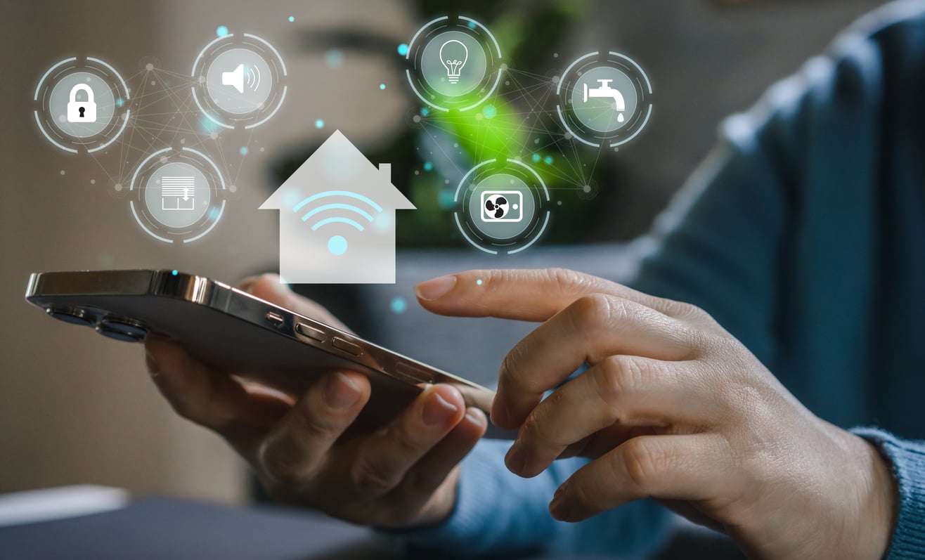 A person uses a smartphone to control smart home devices, with digital icons for security, lighting, water, and more appearing above the phone.
