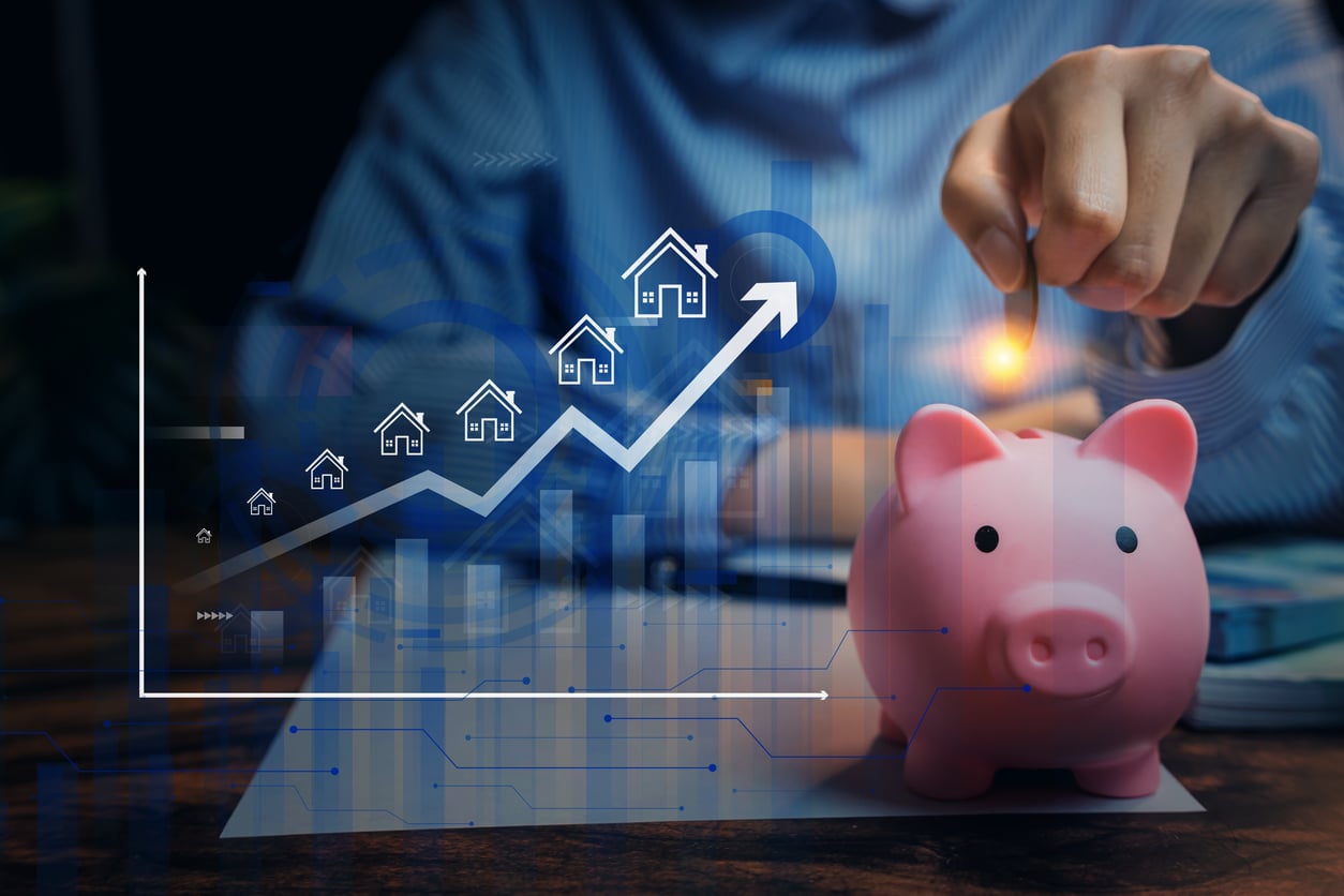 A person drops a coin into a pink piggy bank. In front, a rising graph with house icons and an upward arrow highlights growth in real estate investment or savings, while the background is dark and blurred—subtly hinting at the benefits of renting.
